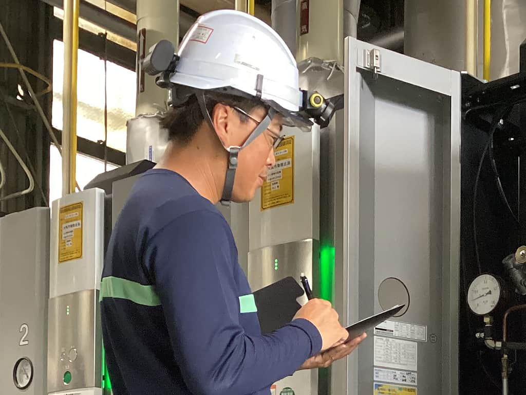 作業着を着た社員が保全設備を確認する様子