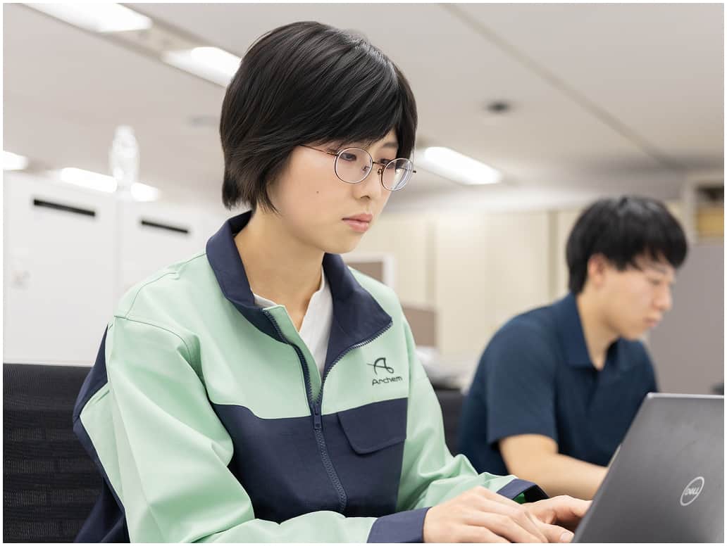 作業着を着た社員がパソコンで製造管理の業務を行う様子