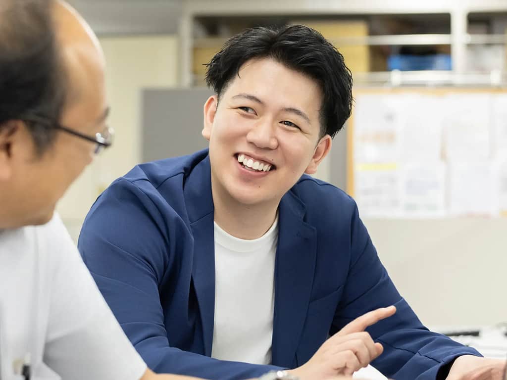 スーツ姿の社員がオフィスで打ち合わせをする様子