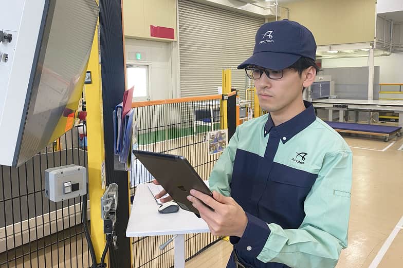 工場内でタブレットを操作する作業員