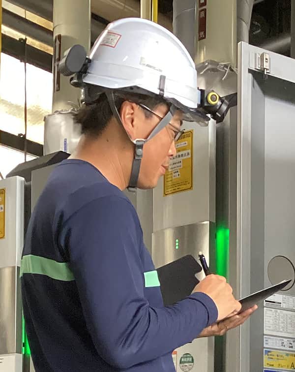ヘルメットを着用した社員が現場で確認する様子