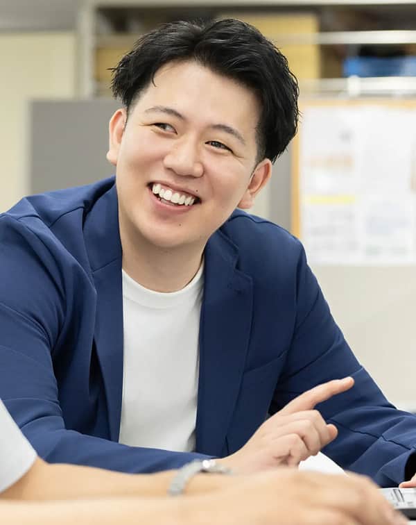 スーツ姿の社員が会議で説明する様子